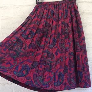 Beautiful deep magenta skirt with pleases and a colourful pattern.